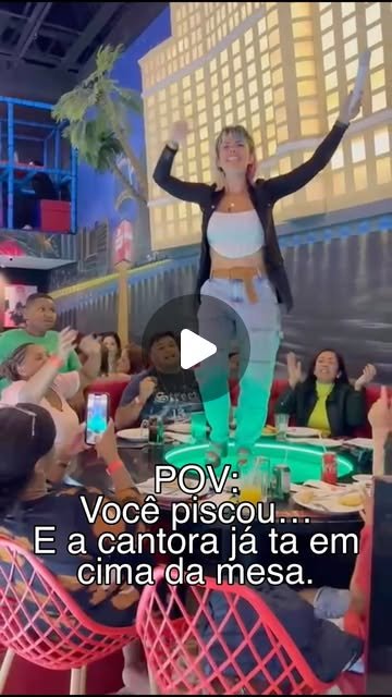 Rafa Guttierrez cantando em cima de mesa em restaurante, plateia animada